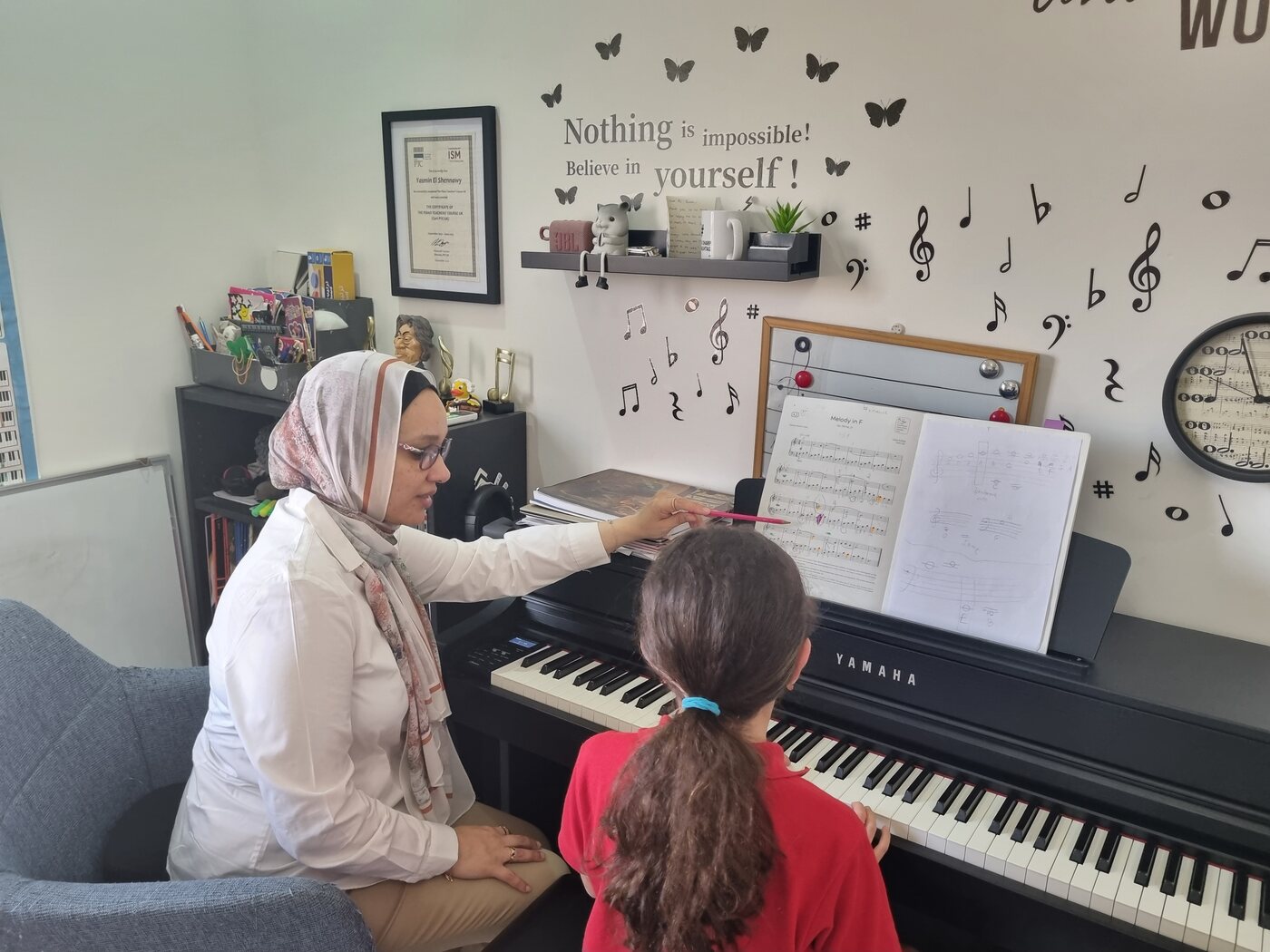 Yasmin Shennawy pointing out a passage in the music to a young student